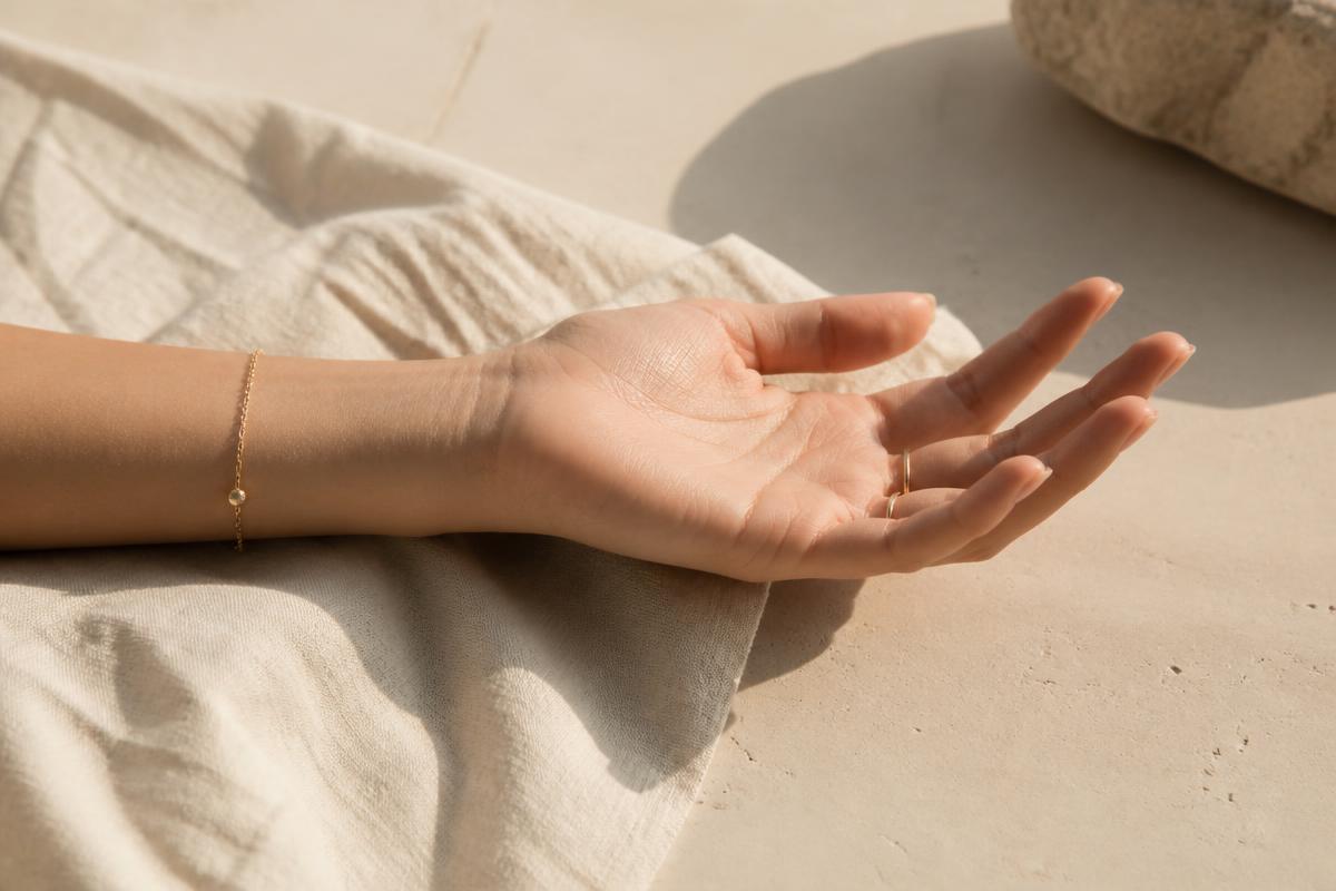 Open palm resting on ivory linen in warm coastal light